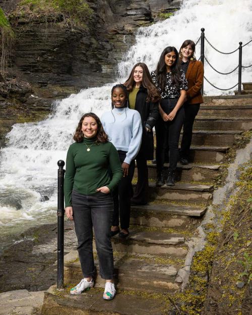 Students standing on a staircase overlooking a rushing waterfall